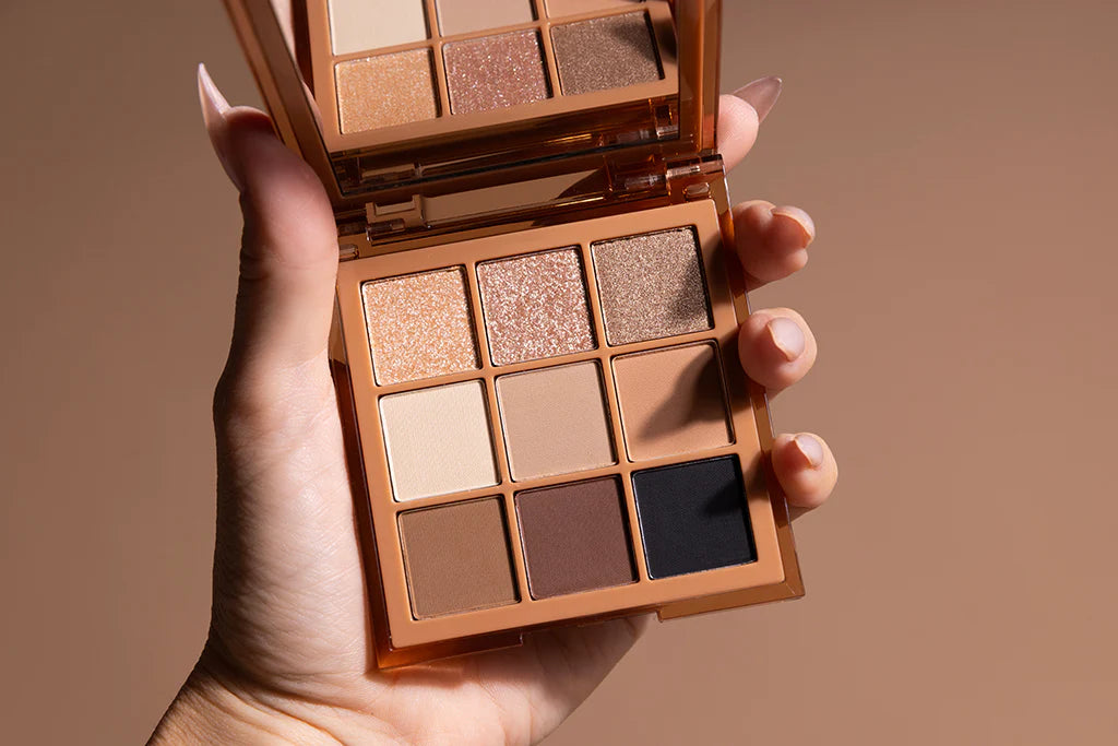 Lottiee Duty Eye Shadow Palette featuring nine shades in a mix of matte and shimmery finishes, presented in a sleek compact with a rose gold casing, held in a hand against a neutral background.