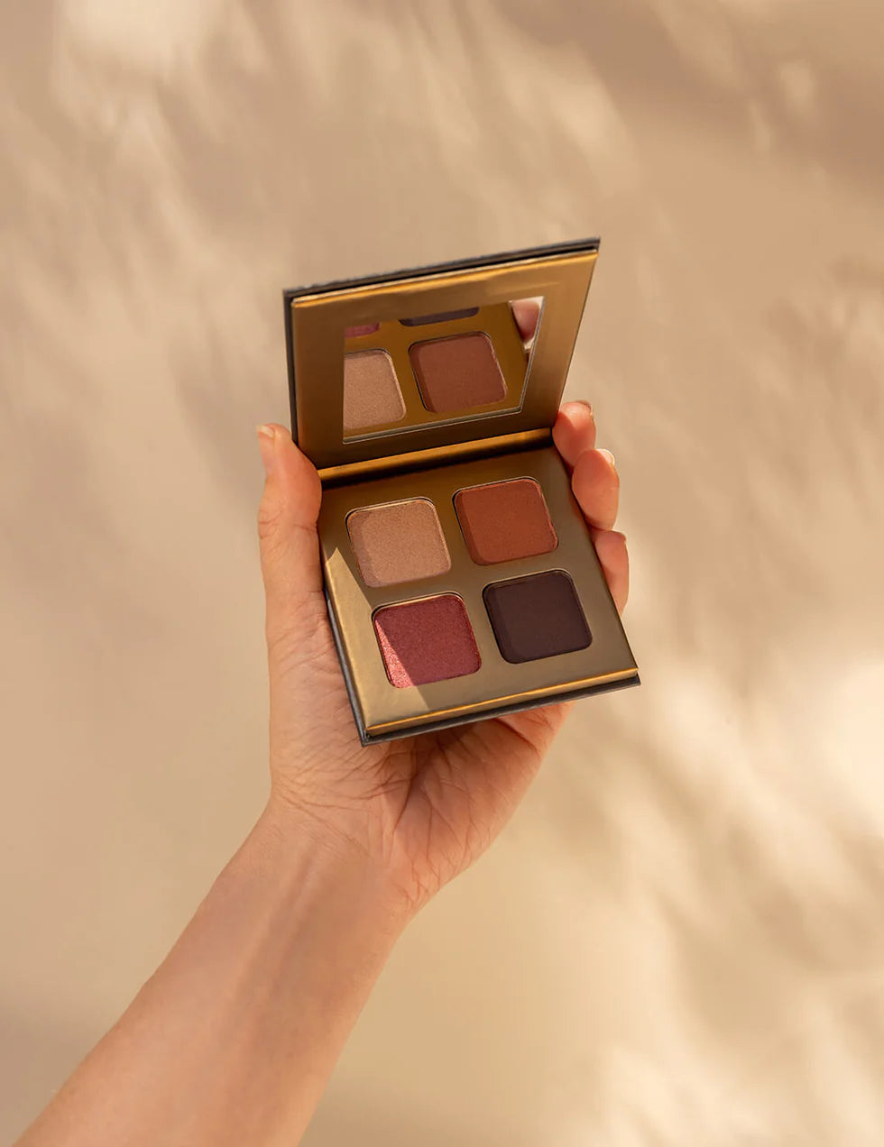 Lottiee Duty Eye Shadow Palette, featuring four shades in a compact format. The palette includes a mirror and is held in a hand, showcasing earthy tones with a combination of matte and shimmer finishes.