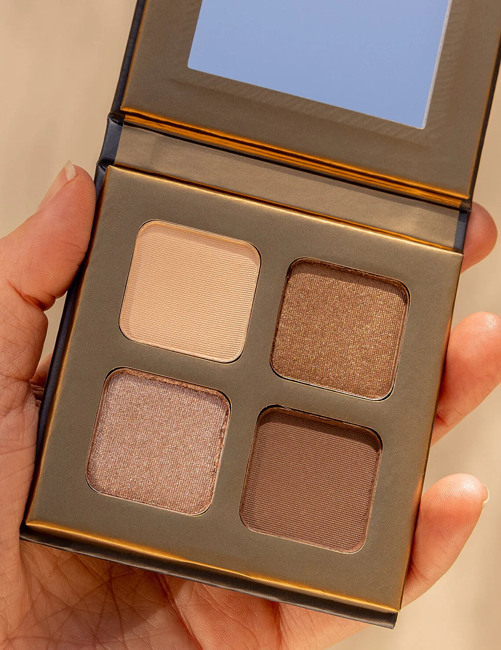Lottiee Duty Eye Shadow Palette featuring four shades, including a light beige, a shimmery bronze, a deep chocolate brown, and an iridescent pink. The palette has a compact design with a mirror on the inside.